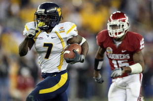 GLENDALE, AZ - JANUARY 02:  Running back Noel Devine #7 of the West Virginia Mountaineers runs for a 65-yard touchdown past Dominique Franks #15 of the Oklahoma Sooners in the second half at the Tostito's Fiesta Bowl at University of Phoenix Stadium January 2, 2008 in Glendale, Arizona.  (Photo by Jed Jacobsohn/Getty Images)