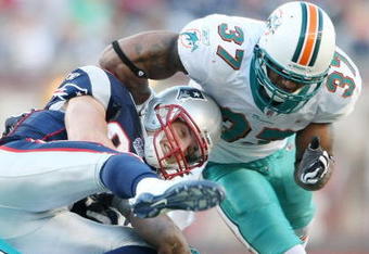 FOXBORO, MA - NOVEMBER 08:  Wes Welker #83 of the New England Patriots is tackled by Yeremiah Bell #37 and Reggie Torbor #53 of the Miami Dolphins on November 8, 2009 at Gillette Stadium in Foxboro, Massachusetts. The Patriots defeated the Dolphins 27-17.  (Photo by Elsa/Getty Images)