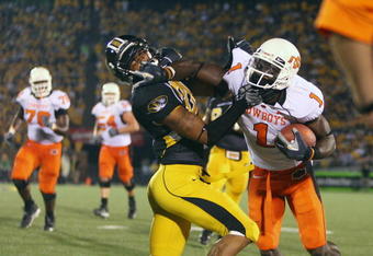 COLUMBIA, MO - OCTOBER 11:  Dez Bryant #1 of the Oklahoma State Cowboys stiff-arms Castine Bridges #21 of the Missouri Tigers  on October 11, 2008 at Memorial Stadium in Columbia, Missouri.  (Photo by G. Newman Lowrance/Getty Images)