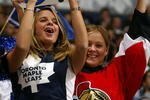 TORONTO - APRIL 8:  Ottawa Senators fan Angela Hamilton of Ottawa shows her loyalty as does friend and Leaf fan Kimberly Raycroft also of Ottawa during game one of round one of the NHL Stanley Cup Playoffs between the Ottawa Senators and the Toronto Maple Leafs at Air Canada Centre on April 8, 2004 in Toronto, Ontario. The Senators won the game 4-2, to take a 1-0 series lead.  (Photo By Dave Sandford/Getty Images)