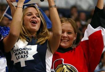 TORONTO - APRIL 8:  Ottawa Senators fan Angela Hamilton of Ottawa shows her loyalty as does friend and Leaf fan Kimberly Raycroft also of Ottawa during game one of round one of the NHL Stanley Cup Playoffs between the Ottawa Senators and the Toronto Maple Leafs at Air Canada Centre on April 8, 2004 in Toronto, Ontario. The Senators won the game 4-2, to take a 1-0 series lead.  (Photo By Dave Sandford/Getty Images)