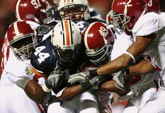 AUBURN, AL - NOVEMBER 24:  Running back Ben Tate #44 of the Auburn Tigers drags a group of Alabama Crimson Tide defenders at Jordan-Hare Stadium on November 24, 2007 in Auburn, Alabama.   (Photo by Doug Benc/Getty Images)