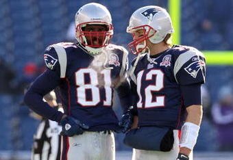 FOXBORO, MA - JANUARY 10:  (L-R) Randy Moss #81 and Tom Brady #12 of the New England Patriots talk on the field during warm ups against the Baltimore Ravens during the 2010 AFC wild-card playoff game at Gillette Stadium on January 10, 2010 in Foxboro, Massachusetts.  (Photo by Jim Rogash/Getty Images)