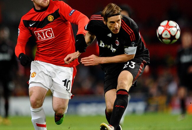 MANCHESTER, ENGLAND - MARCH 10: Wayne Rooney of Manchester United battles with Massimo Ambrosini of AC Milan during the UEFA Champions League First Knockout Round, second leg match between Manchester United and AC Milan at Old Trafford on March 10, 2010 in Manchester, England. (Photo by Laurence Griffiths/Getty Images) 