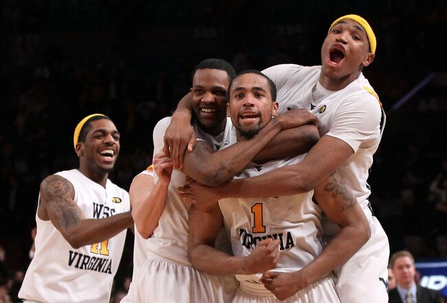 NEW YORK - MARCH 11: Da'Sean Butler #1 of the West Virginia Mountaineers celebrates with teammates John Flowers #41, Devin Ebanks #3 and Kevin Jones #5 after making a game winning three pointer to defeat the Cincinnati Bearcats during the quarterfinal of the 2010 NCAA Big East Tournament at Madison Square Garden on March 11, 2010 in New York City.  (Photo by Jim McIsaac/Getty Images)