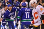 VANCOUVER, CANADA - MARCH 14: Alex Burrows #14 of the Vancouver Canucks celebrates with teammate Ryan Kesler #17 after scoring a goal while Craig Conroy #24 of the Calgary Flames skates past during the first period of NHL action on March 14, 2010 at General Motors Place in Vancouver, British Columbia, Canada.  (Photo by Rich Lam/Getty Images)