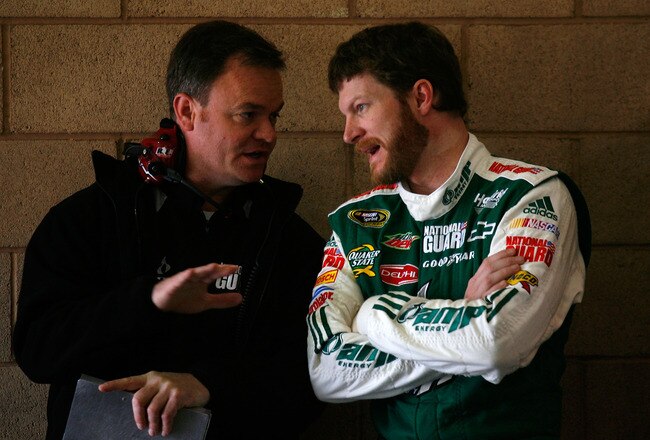 FONTANA, CA - FEBRUARY 20:  Dale Earnhardt Jr., driver of the #88 AMP Energy Juice/National Guard Chevrolet, speaks with Crew Chief Lance McGrew in the garage area during practice for the NASCAR Sprint Cup Series Auto Club 500 at Auto Club Speedway on February 20, 2010 in Fontana, California.  (Photo by Jason Smith/Getty Images for NASCAR)