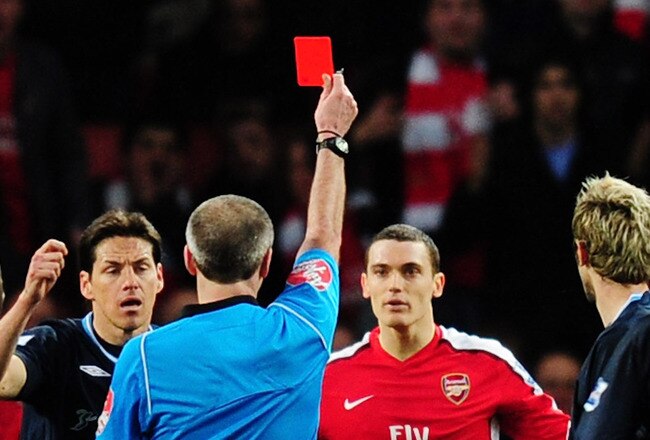 LONDON, ENGLAND - MARCH 20:   referee Martin Atkinson shows Thomas Vermaelen of Arsenal the red card during the Barclays Premier League match between Arsenal and West Ham United at Emirates Stadium on March 20, 2010 in London, England.  (Photo by Mike Hewitt/Getty Images)