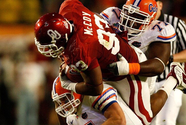 MIAMI - JANUARY 08:  Gerald McCoy #93 of the Oklahoma Sooners is tackled by Tim Tebow #15 and Jason Watkins #77 of the Florida Gators during the first half of the FedEx BCS National Championship game at Dolphin Stadium on January 8, 2009 in Miami, Florida.  (Photo by Marc Serota/Getty Images)