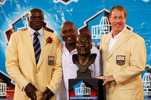 CANTON, OH - AUGUST 8: Bruce Smith looks on with former Buffalo Bills teammates Thurman Thomas (center) and Jim Kelly following his induction into the Pro Football Hall of Fame during the 2009 enshrinement ceremony at Fawcett Stadium on August 8, 2009 in Canton, Ohio. (Photo by Joe Robbins/Getty Images)