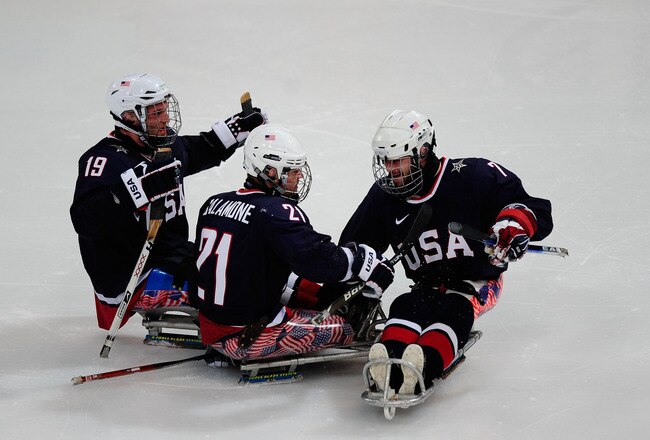 VANCOUVER, BC - MARCH 16:  Alexi Salamone #21 of the United States celebrates his goal with teammates Taylor Lipsett #7 and Taylor Chace #19 during the Ice Sledge Hockey Preliminary Round Group A Game on day five of the 2010 Vancouver Winter Paralympic Games at UBC Thunderbird Arena on March 16, 2010 in Vancouver, Canada.   The United States defeated Japan 6-0. (Photo by Jamie McDonald/Getty Images)