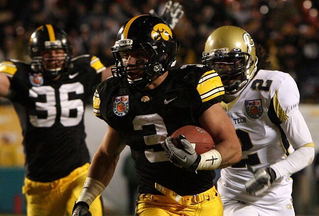 MIAMI GARDENS, FL - JANUARY 05:  Brandon Wegher #3 of the Iowa Hawkeyes scores a 32-yard rushing touchdown late in the fourth quarter against Mario Butler #2 of the Georgia Tech Yellow Jackets during the FedEx Orange Bowl at Land Shark Stadium on January 5, 2010 in Miami Gardens, Florida.  Iowa won 24-14. (Photo by Doug Benc/Getty Images)