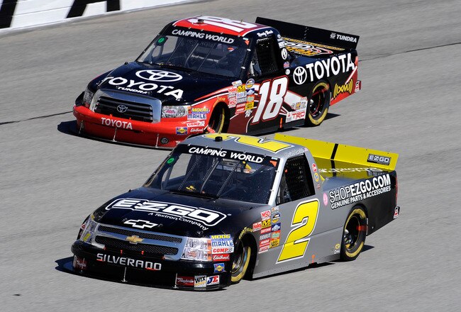 ATLANTA - MARCH 06:  Kyle Busch, driver of the #18 Toyota Tundra Toyota, and Kevin Harvick, driver of the #2 E-Z-GO Chevrolet, race side by side during the NASCAR Camping World Truck Series E-Z-GO 200 at Atlanta Motor Speedway on March 6, 2010 in Hampton, Georgia.  (Photo by John Harrelson/Getty Images)