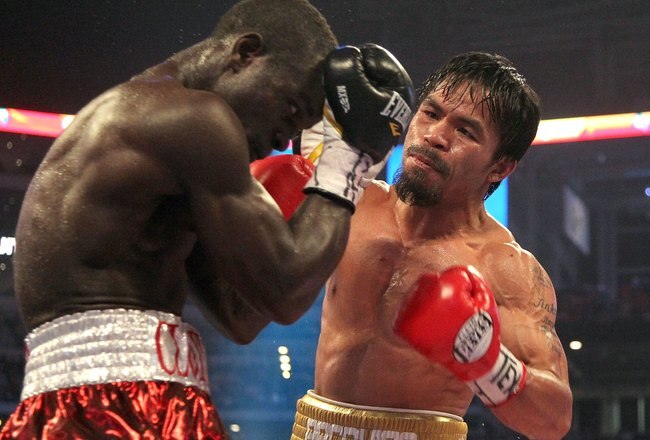 ARLINGTON, TX - MARCH 13:  (R-L) Manny Pacquiao of the Philippines throws a right to the head of Joshua Clottey of Ghana during the WBO welterweight title fight at Cowboys Stadium on March 13, 2010 in Arlington, Texas. Pacquiao defeated Clottey by unanimous decision.  (Photo by Jed Jacobsohn/Getty Images)