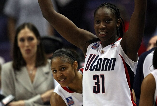ST. LOUIS - APRIL 05:  Maya Moore #23 of the Connecticut Huskies peeks around a celebrating Tina Charles #31 as former Connecticut player Rebecca Lobo looks on on April 5, 2009 during the Womens Final Four Semifinals at the Scottrade Center on April 5, 2009 in St. Louis, Missouri. Connecticut defeated the Stanford Cardinal 83-64.  (Photo by Elsa/Getty Images)