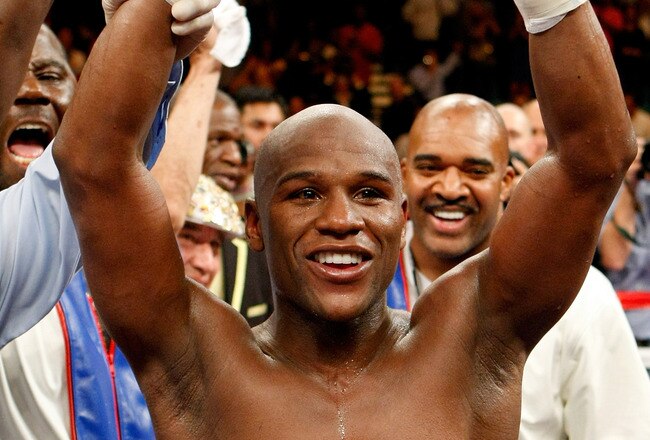 LAS VEGAS - SEPTEMBER 19:  Floyd Mayweather Jr., with his advisor Leonard Ellerbe behind him, celebrates his unanimous-decision victory over Juan Manuel Marquez at the MGM Grand Garden Arena September 19, 2009 in Las Vegas, Nevada.  (Photo by Ethan Miller/Getty Images)