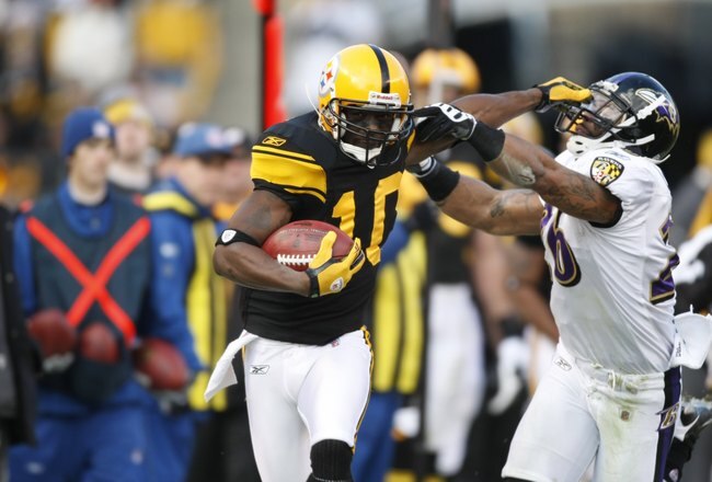 PITTSBURGH - DECEMBER 27:  Santonio Holmes #10 of the Pittsburgh Steelers stiff arms Dawan Landry #26 of the Baltimore Ravens on December 27, 2009 at Heinz Field in Pittsburgh, Pennsylvania. (Photo by Gregory Shamus/Getty Images)
