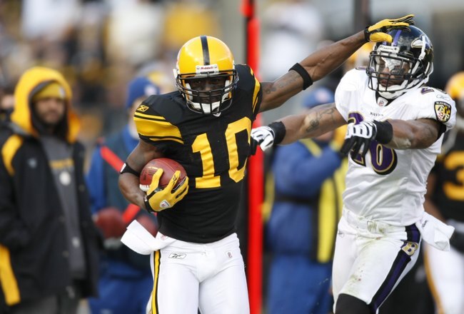 PITTSBURGH - DECEMBER 27:  Santonio Holmes #10 of the Pittsburgh Steelers stiff arms Dawan Landry #26 of the Baltimore Ravens on December 27, 2009 at Heinz Field in Pittsburgh, Pennsylvania. (Photo by Gregory Shamus/Getty Images)