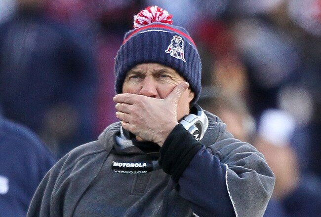 FOXBORO, MA - JANUARY 10:  Head coach Bill Belichick of the New England Patriots covers his mouth as he looks on against the Baltimore Ravens during the 2010 AFC wild-card playoff game at Gillette Stadium on January 10, 2010 in Foxboro, Massachusetts.  (Photo by Al Bello/Getty Images)