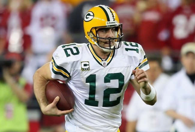 GLENDALE, AZ - JANUARY 10:  Quarterback Aaron Rodgers #12 of the Green Bay Packers scrambles with the ball during the 2010 NFC wild-card playoff game against the Arizona Cardinals at the Universtity of Phoenix Stadium on January 10, 2010 in Glendale, Arizona.  The Cardinals defeated the Packers  51-45 in overtime.  (Photo by Christian Petersen/Getty Images)