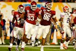 MIAMI - JANUARY 08:  (L-R) Keenan Calhoun #22, Gerald McCoy #93 and Adrian Taylor #86 of the Oklahoma Sooners celebrate a defensive stop against the Florida Gators during the FedEx BCS National Championship game at Dolphin Stadium on January 8, 2009 in Miami, Florida.  (Photo by Marc Serota/Getty Images)