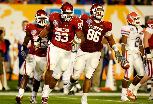 MIAMI - JANUARY 08:  (L-R) Keenan Calhoun #22, Gerald McCoy #93 and Adrian Taylor #86 of the Oklahoma Sooners celebrate a defensive stop against the Florida Gators during the FedEx BCS National Championship game at Dolphin Stadium on January 8, 2009 in Miami, Florida.  (Photo by Marc Serota/Getty Images)