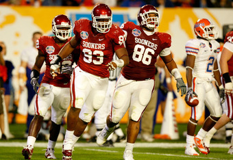 MIAMI - JANUARY 08:  (L-R) Keenan Calhoun #22, Gerald McCoy #93 and Adrian Taylor #86 of the Oklahoma Sooners celebrate a defensive stop against the Florida Gators during the FedEx BCS National Championship game at Dolphin Stadium on January 8, 2009 in Miami, Florida.  (Photo by Marc Serota/Getty Images)