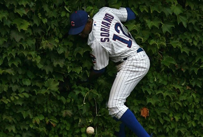 CHICAGO - AUGUST 28: Alfonso Soriano #12 of the Chicago Cubs hits the outfield wall after missing a catch against the New York Mets on August 28, 2009 at Wrigley Field in Chicago, Illinois. The Cubs defeated the Mets 5-2. (Photo by Jonathan Daniel/Getty Images)