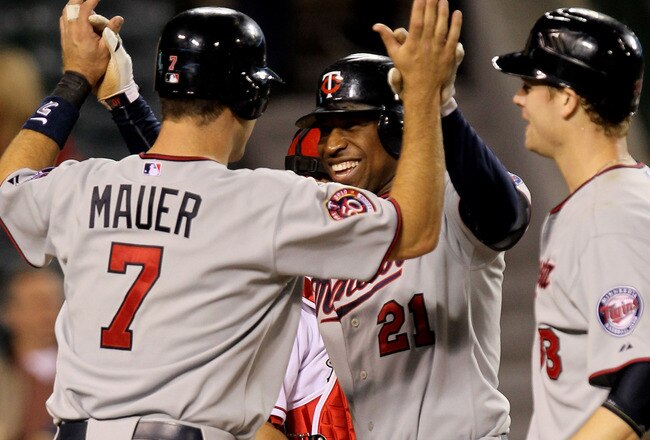ANAHEIM, CA - APRIL 8: Delmon Young #21 of the Minnesota Twins is greeted by Joe Mauer #7 and Justin Morneau #33 after they all score on Young's three run home run in the ninth inning against the Los Angeles Angels of Anaheim on April 8, 2010 at Angel Stadium in Anaheim, California.  The Twins won 10-1.   (Photo by Stephen Dunn/Getty Images)