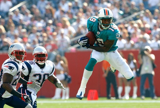 FOXBORO, MA - SEPTEMBER 21:  Ted Jr. Ginn #19 of the Miami Dolphins catches a pass despite the defense of Ellis Hobbs #27 and James Sanders #36 of the New England Patriots at Gillette Stadium on September 21, 2008 in Foxboro, Massachusetts. (Photo by Jim Rogash/Getty Images)