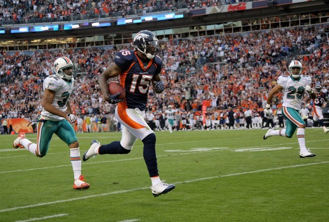 DENVER - NOVEMBER 02:  Wide receiver Brandon Marshall #15 of the Denver Broncos makes a reception and eludes the defense of Jason Allen #32 and Tyrone Culver #29 of the Miami Dolphins before being nulified by a penalty during NFL action at Invesco Field at Mile High on November 2, 2008 in Denver, Colorado. The Dolphins defeated the Broncos 26-17.  (Photo by Doug Pensinger/Getty Images)