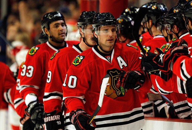 CHICAGO - APRIL 11: (R-L) Patrick Sharp #10, Jonathan Toews #19 and Dustin Byfuglien #33 of the Chicago Blackhawks receive congratulations from teammates after a first-period goal against the Detroit Red Wings at the United Center on April 11, 2010 in Chicago, Illinois. (Photo by Jonathan Daniel/Getty Images)