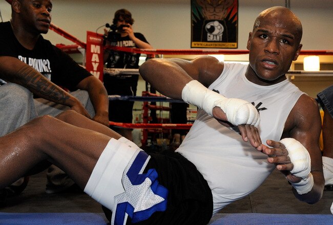 LAS VEGAS - APRIL 14:  Boxer Floyd Mayweather Jr. does sit-ups during a workout as his camp coordinator DeJuan Blake looks on April 14, 2010 in Las Vegas, Nevada. Mayweather is scheduled to face Shane Mosley in a 12-round welterweight bout on May 1, 2010 in Las Vegas.  (Photo by Ethan Miller/Getty Images)