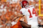 DALLAS - OCTOBER 17:  Quarterback Sam Bradford #14 of the Oklahoma Sooners is tackled by Lamarr Houston #33 of the Texas Longhorns at Cotton Bowl on October 17, 2009 in Dallas, Texas.  (Photo by Ronald Martinez/Getty Images)