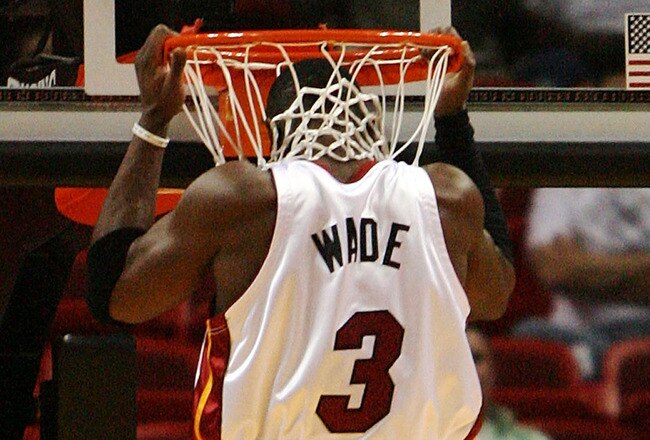 MIAMI - NOVEMBER 19:  Dwyane Wade #3 of the Miami Heat lifts himself into the net prior to taking on the Toronto Raptors at American Airlines Arena on November 19, 2008 in Miami, Florida. NOTE TO USER: User expressly acknowledges and agrees that, by downloading and/or using this Photograph, user is consenting to the terms and conditions of the Getty Images License Agreement.  (Photo by Doug Benc/Getty Images)