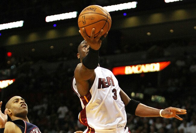 MIAMI - NOVEMBER 10:  Dwyane Wade #3 of the Miami Heat scores past Vince Carter #15 of the New Jersey Nets at American Airlines Arena on November 10, 2008 in Miami, Florida. The Heat defeated the Nets 99-94. NOTE TO USER: User expressly acknowledges and agrees that, by downloading and/or using this Photograph, user is consenting to the terms and conditions of the Getty Images License Agreement.  (Photo by Doug Benc/Getty Images)