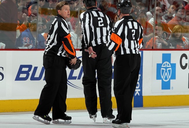 PHILADELPHIA - APRIL 11:  Referee Kerry Fraser #2 (L) is honored during the game between the New York Rangers and the Philadelphia Flyers by linesman Don Henderson and referee Kelly Sutherland (R) as they wear Fraser's #2 on their jerseys on April 11, 2010 at Wachovia Center in Philadelphia, Pennsylvania. The game was Fraser's final game in the NHL as he is retiring after 30 years in the league.The Flyers defeated the Rangers 2-1 after a shootout. The victory clinched a playoff berth for Philadelphia.  (Photo by Jim McIsaac/Getty Images)