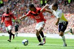 MANCHESTER, ENGLAND - APRIL 24:  Nani of Manchester United competes for the ball with Benoit Assou-Ekotto of Tottenham Hotspur during the Barclays Premier League match between Manchester United and Tottenham Hotspur at Old Trafford on April 24, 2010 in Manchester, England.  (Photo by Michael Regan/Getty Images)
