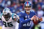 EAST RUTHERFORD, NJ - DECEMBER 27:  Eli Manning #10 of the New York Giants is chased down Charles Johnson #95 of the Carolina Panthers at Giants Stadium on December 27, 2009 in East Rutherford, New Jersey.  (Photo by Nick Laham/Getty Images)