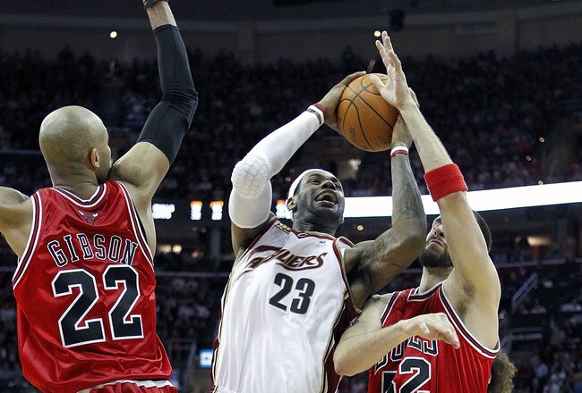 CLEVELAND - APRIL 27:  LeBron James #23 of the Cleveland Cavaliers tries to get a shot off between Taj Gibson #22 and Brad Miller #52 of the Chicago Bulls in Game Five of the Eastern Conference Quarterfinals during the 2010 NBA Playoffs at Quicken Loans Arena on April 27, 2010 in Cleveland, Ohio. Cleveland won the game 96-94 to win the series 4-1. NOTE TO USER: User expressly acknowledges and agrees that, by downloading and or using this photograph, User is consenting to the terms and conditions of the Getty Images License Agreement.  (Photo by Gregory Shamus/Getty Images)