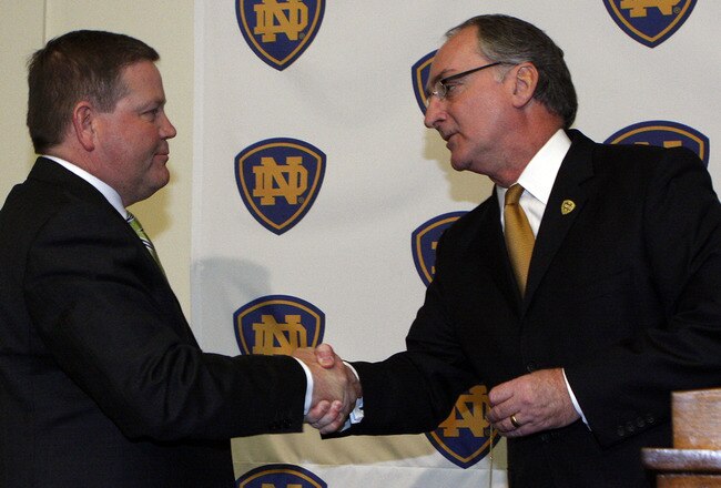 SOUTH BEND, IN - DECEMBER 11: Notre Dame atheletic director Jack Swarbrick (R) greets Brian Kelly as he is introduced as the new football head coach at Notre Dame University on December 11, 2009 in South Bend, Indiana.  Kelly most recently led the University of Cincinnati to two consecutive Bowl Championship Series appearances including a perfect 12-0 record this past season. (Photo by Frank Polich/Getty Images)