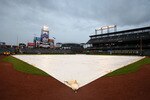 DENVER - APRIL 23:  The tarp covers the infield as rain falls postponing the game between the Florida Marlins and the Colorado Rockies at Coors Field on April 23, 2010 in Denver, Colorado. The game was rescheduled as the first game of a double header on April 24, 2010.  (Photo by Doug Pensinger/Getty Images)