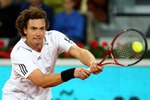 MADRID, SPAIN - MAY 14:  Ernests Gulbis of Latvia plays a backhand against  Roger Federer of Switzerland in their quarter final match during the Mutua Madrilena Madrid Open tennis tournament at the Caja Magica on May 14, 2010 in Madrid, Spain.  (Photo by Clive Brunskill/Getty Images)