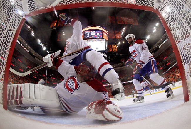 PHILADELPHIA - MAY 16:  Travis Moen #32 of the Montreal Canadiens gets tangled up with Jaroslav Halak #41 against the Philadelphia Flyers in Game 1 of the Eastern Conference Finals during the 2010 NHL Stanley Cup Playoffs at Wachovia Center on May 16, 2010 in Philadelphia, Pennsylvania.  (Photo by Jim McIsaac/Getty Images)