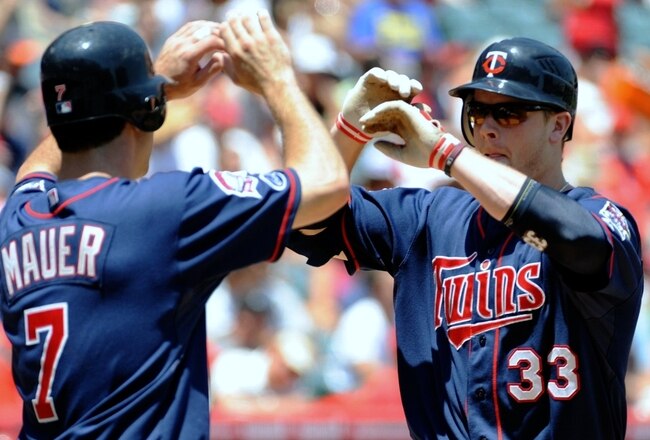 ANAHEIM, CA - JULY 26:  Justin Morneau #33 of the Minnesota Twins celebrates his two-run home run with teammate Joe Mauer #7 during the first inning against the Los Angeles Angels of Anaheim at Angels Stadium on July 26, 2009 in Anaheim, California. (Photo by Harry How/Getty Images)