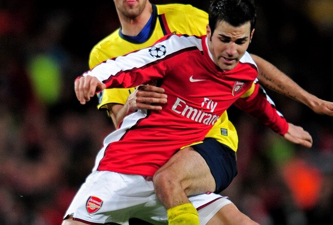 LONDON, ENGLAND - MARCH 31:  Cesc Fabregas of Arsenal is tackled by Sergio Busquets of Barcelona during the UEFA Champions League quarter final first leg match between Arsenal and FC Barcelona at the Emirates Stadium on March 31, 2010 in London, England.  (Photo by Shaun Botterill/Getty Images)