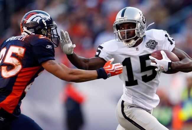 DENVER - DECEMBER 20:  Johnnie Lee Higgins #15 of the Oakland Raiders stiff arms Tony Carter #25 of the Denver Broncos in the first half at Invesco Field at Mile High on December 20, 2009 in Denver, Colorado. The Raiders defeated the Broncos 20-19.  (Photo by Jeff Gross/Getty Images)