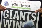 GLENDALE, AZ - FEBRUARY 03:  Defensive end Michael Strahan #92 of the New York Giants holds a newspaper with the headline 'GIANTS WIN!' after the Giants defeated the New England Patriots 17-14 during Super Bowl XLII on February 3, 2008 at the University of Phoenix Stadium in Glendale, Arizona.  (Photo by Donald Miralle/Getty Images)
