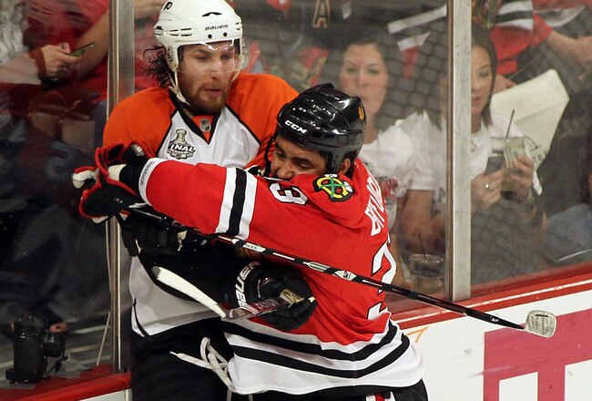 CHICAGO - MAY 29:  Dustin Byfuglien #33 of the Chicago Blackhawks checks Braydon Coburn #5 of the Philadelphia Flyers into the boards in the second period in Game One of the 2010 NHL Stanley Cup Final at the United Center on May 29, 2010 in Chicago, Illinois.  (Photo by Andre Ringuette/Getty Images)