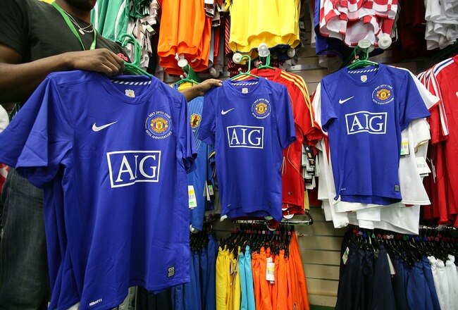 LONDON - SEPTEMBER 16:  AIG sponsored Manchester United football shirts are displayed for sale on September16, 2008 in London. The giant American insurer is experiencing difficulties as a result of the credit crunch and the downturn in the economy.  (Photo by Peter Macdiarmid/Getty Images)
